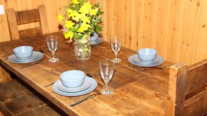 Ein Holztisch gedeckt mit Schüsseln, Tellern und Weingläsern.