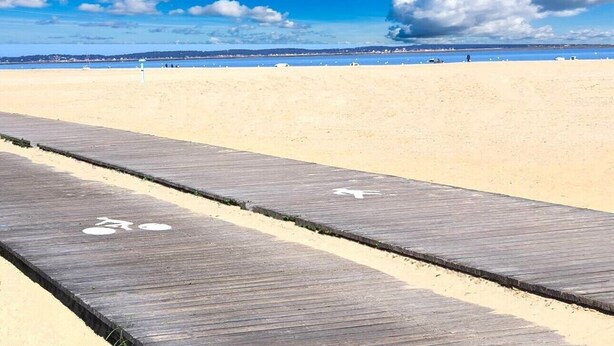 A wooden boardwalk leading to a sandy beach with a clear blue sky and distant shoreline. - Arcachon beautiful 12m2 terrace with Harbour View and beach Classified 3 * (Arcachon)