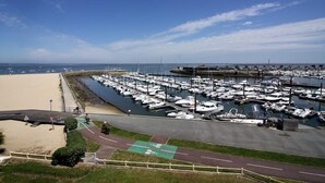 A marina with numerous boats docked, a sandy beach, and a clear blue sky. - Arcachon beautiful 12m2 terrace with Harbour View and beach Classified 3 * (Arcachon)