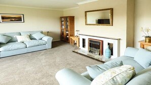 A living room with a sofa, a fireplace, and a cabinet.