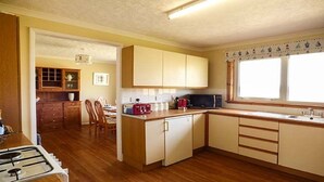 A compact kitchen with wooden cabinets, a microwave, and a gas stove.