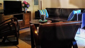 A living room with a sofa, armchairs, a television, a lamp, and framed pictures on the wall. - Casa Marola, house with character (Gabicce Mare)