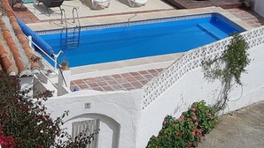 A rooftop swimming pool with a blue interior, surrounded by white railings, and equipped with lounge chairs and a hot tub. - Ranch Studio in Quiet White Village Setting with shared Pool and Hot Tub (Castell de Ferro)