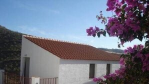 A white building with a red-tiled roof, a small balcony, and a potted plant. - Ranch Studio in Quiet White Village Setting with shared Pool and Hot Tub (Castell de Ferro)