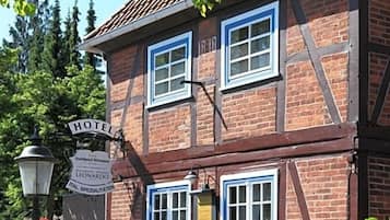 Een traditioneel vakwerkhuis met een bordje dat aangeeft dat het een hotel is.
