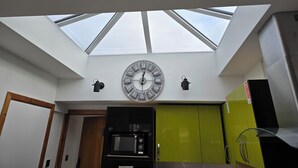 A modern kitchen with a skylight, a large wall clock, and a microwave. - Coppice, Entire 1 bedroom annex, pet friendly. EV Charger.  (Barton on Sea)