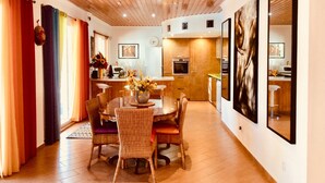 A modern kitchen with wooden cabinets, a built-in oven, and a microwave. - Spacious Villa with Private, Sunny Garden, Sea View and Exclusive Pool  (Playa Blanca)