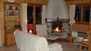 Ein gemütliches Zimmer mit Kamin, Bücherregal und einer bequemen Sitzecke.