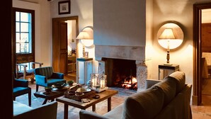 A cozy living room with a fireplace, comfortable seating, and a table with decorative items. - **PREMIUM PROPERTY** Beautiful finca with spectacular views and HEATED POOL (In Esporles)