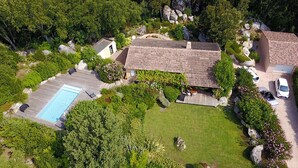 Vista aérea de una propiedad con piscina, terraza cubierta y jardín.