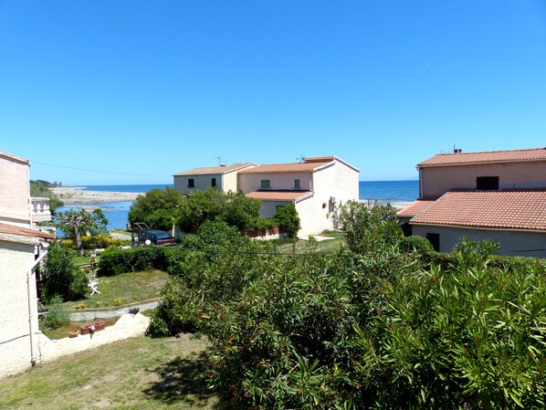 Eine Wohngegend an der Küste mit Häusern, blauem Himmel und Blick aufs Meer.