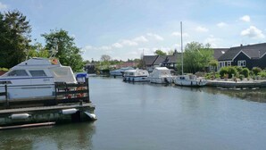 A calm canal with several boats docked along the sides.