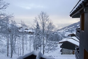Eine verschneite Berglandschaft mit einem Holzhaus und Balkonen.
