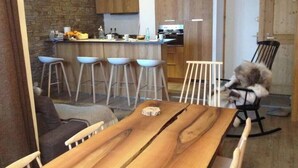 Una cocina moderna con armarios de madera, una barra con taburetes y una mesa de comedor con sillas.