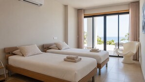A hotel room with two beds, a chair, and a view of the sea. - Luxury villa with private infinity pool and magnificient sea views (Lagos)