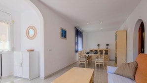 Una habitación con cama, escritorio y kitchenette.