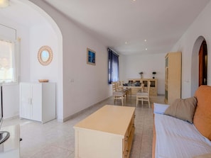 A room with a bed, a desk, and a kitchenette.