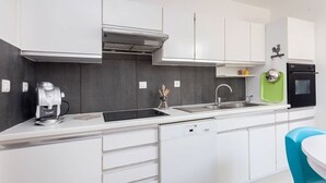 A modern kitchen with white cabinets, a dishwasher, a coffee machine, and a sink. - Beautiful house with big garden and private pool (Mazan)