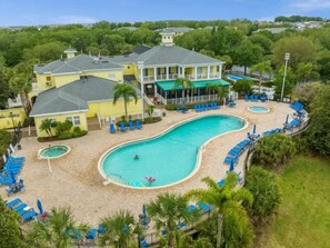A resort with a large swimming pool, multiple lounge areas, and a building with a balcony overlooking the pool. - 3 Bedroom Apartment near Disney World (Davenport)