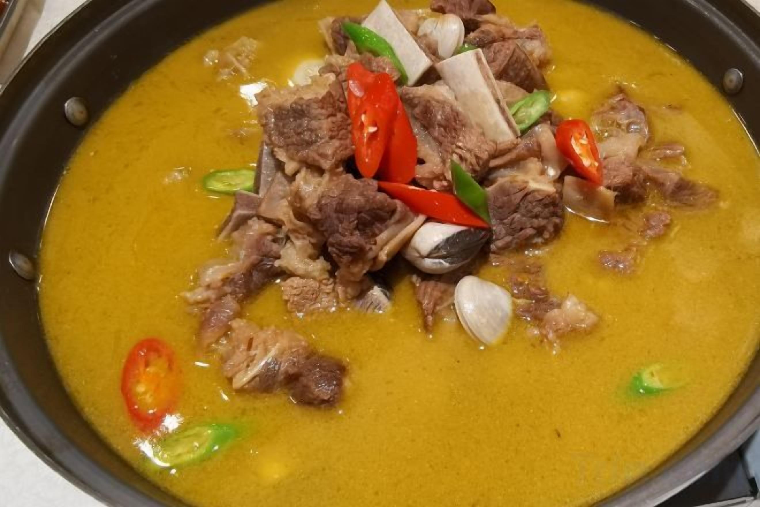 A dish with meat and vegetables in a yellow sauce.
