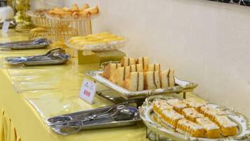 A buffet table with various food items and serving utensils.