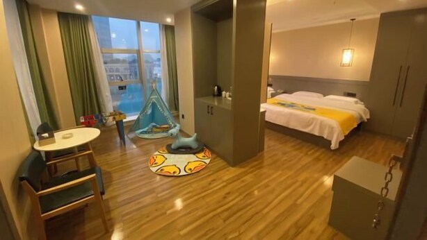 Una habitación de hotel con cama, escritorio, silla, armario y vistas a la ciudad.