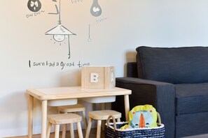 A child's desk with a wooden chair, a small table, and a basket with toys. - Feel Porto Syrah Townhouse (Oporto)