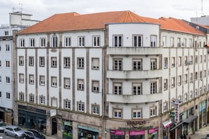 Ein mehrgeschossiges Gebäude mit rotem Ziegeldach, mit einem Café im Erdgeschoss und einer sichtbaren Schaufensterfront.