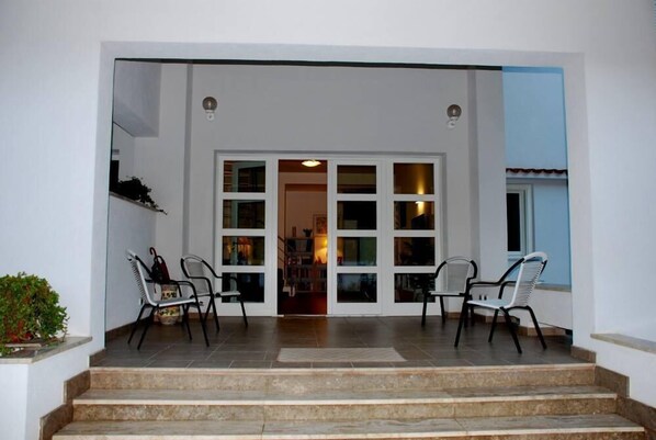 A set of steps leading to a door with glass panels, flanked by two chairs. - Geneva villa, a holiday you will never forget (Palermo)