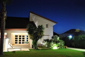 A modern two-story house with a well-lit front porch, a large window, and a neatly landscaped garden. - Geneva villa, a holiday you will never forget (Palermo)
