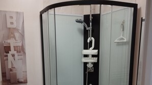 A corner shower with a glass enclosure, a toilet, and a small sink. - rent pretty calm and pleasant studio (Bagnoles De L'orne Normandie)