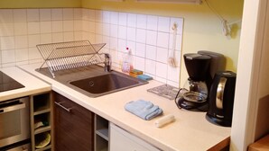 A kitchen with a sink, a coffee maker, and a dish rack. - rent pretty calm and pleasant studio (Bagnoles De L'orne Normandie)