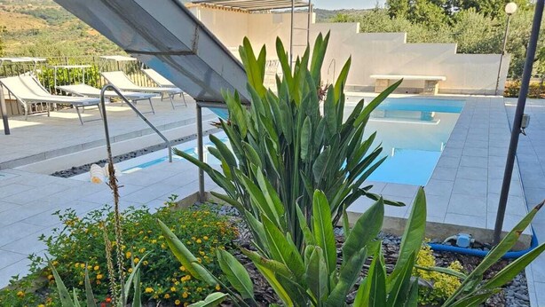 A rooftop pool area with a view of the surrounding landscape, including a pool and lounge chairs. - Villa surrounded by greenery with private pool  (Palazzolo Acreide)
