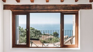 A balcony with a view of the sea, wooden beams, and a railing.