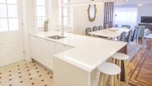 Eine moderne Küche mit Kochinsel, Barhocker und einer Kandelaberleuchte.