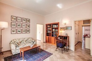 A living room with a sofa, coffee table, and a bookshelf.