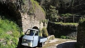 A blue truck parked on a narrow stone path beside a stone wall. - Historic House With Stunning Mountain Views in the heart of the village      (Pigna)