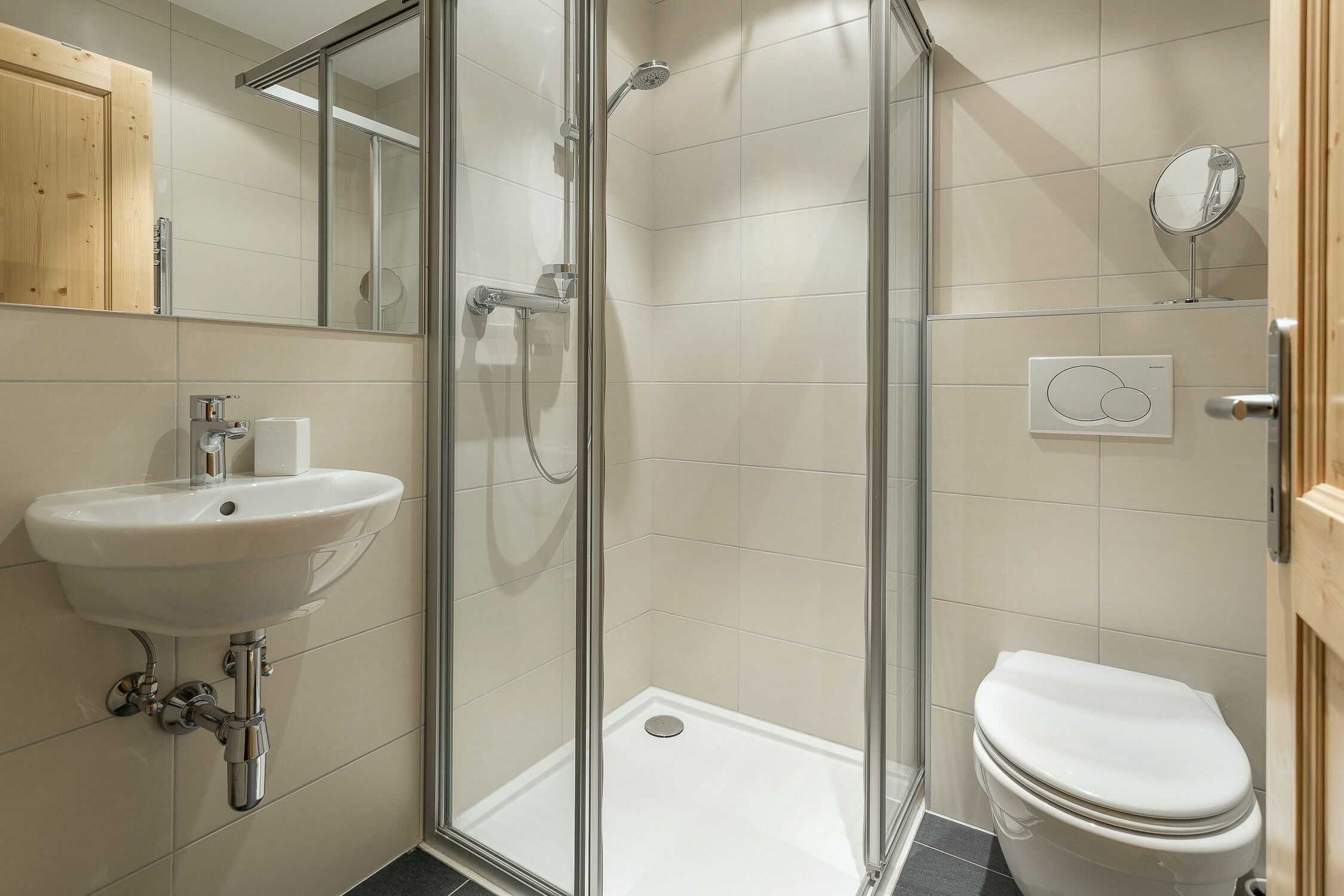 A bathroom with a glass-enclosed shower, a sink, and a toilet.