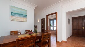 Un comedor con mesa de madera, sillas y un cuadro en la pared.