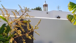 Un edificio blanco con una pequeña torre y antena.