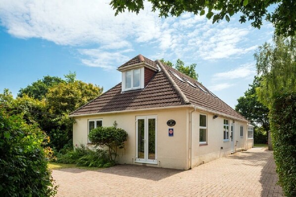 Ein eingeschossiges Haus mit Ziegeldach, einer Haustür und einem kleinen Fenster.