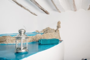 Experience a serene retreat with a minimalist design, featuring a textured mural and elegant lantern.