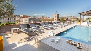 Ein Poolbereich auf dem Dach mit Liegestühlen und einem Pool.