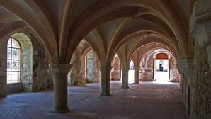 An interior with arched ceilings and stone columns, featuring a central open space with a view to a distant structure. - Picturesque. A modern barn conversion, sleeps 5. Stunning views. (Frôlois)