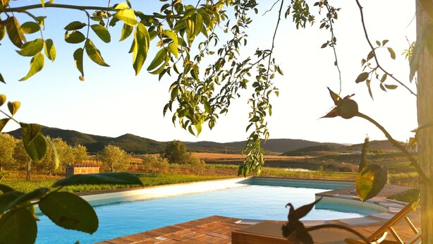 Ein Schwimmbecken mit Liegestühlen und Blick auf die Landschaft.