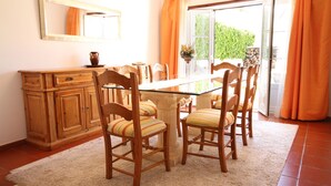 A dining area with a glass table, wooden chairs, and a wooden cabinet. - Fantastic Villa With Private Pool In Vilamoura  (Vilamoura)