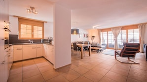 A modern kitchen with wooden cabinets and a dining area with a table and chairs.
