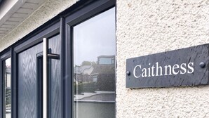 A building entrance with a sign reading "Caithness" and a set of double doors. - Caithness Holiday Home (Pontypool)