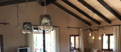 Una cocina con isla de madera, microondas y luces colgantes.