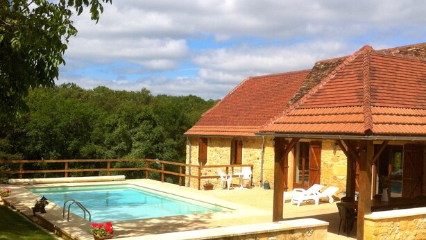 A stone building with a swimming pool, wooden deck, and lounge chairs. - Renovated Traditional Stone House With Private Salt Water Pool  (Gourdon)